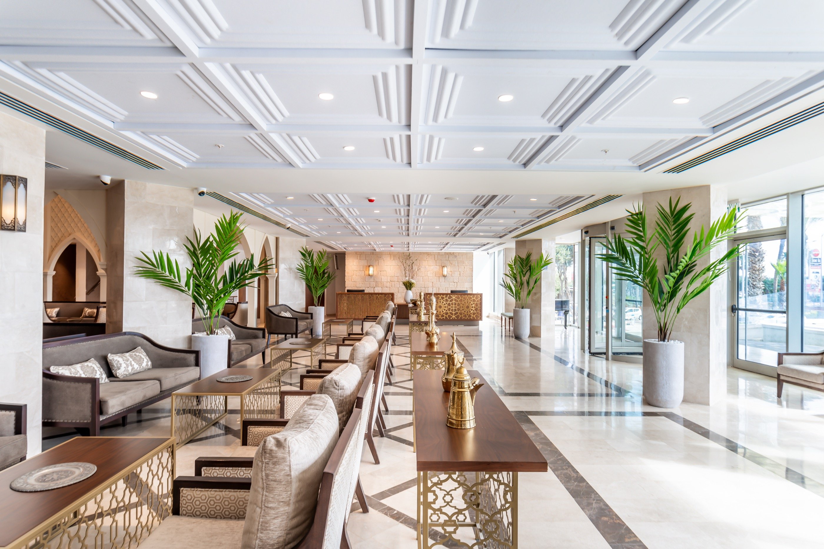The long lobby — mirrored bar, green palms.