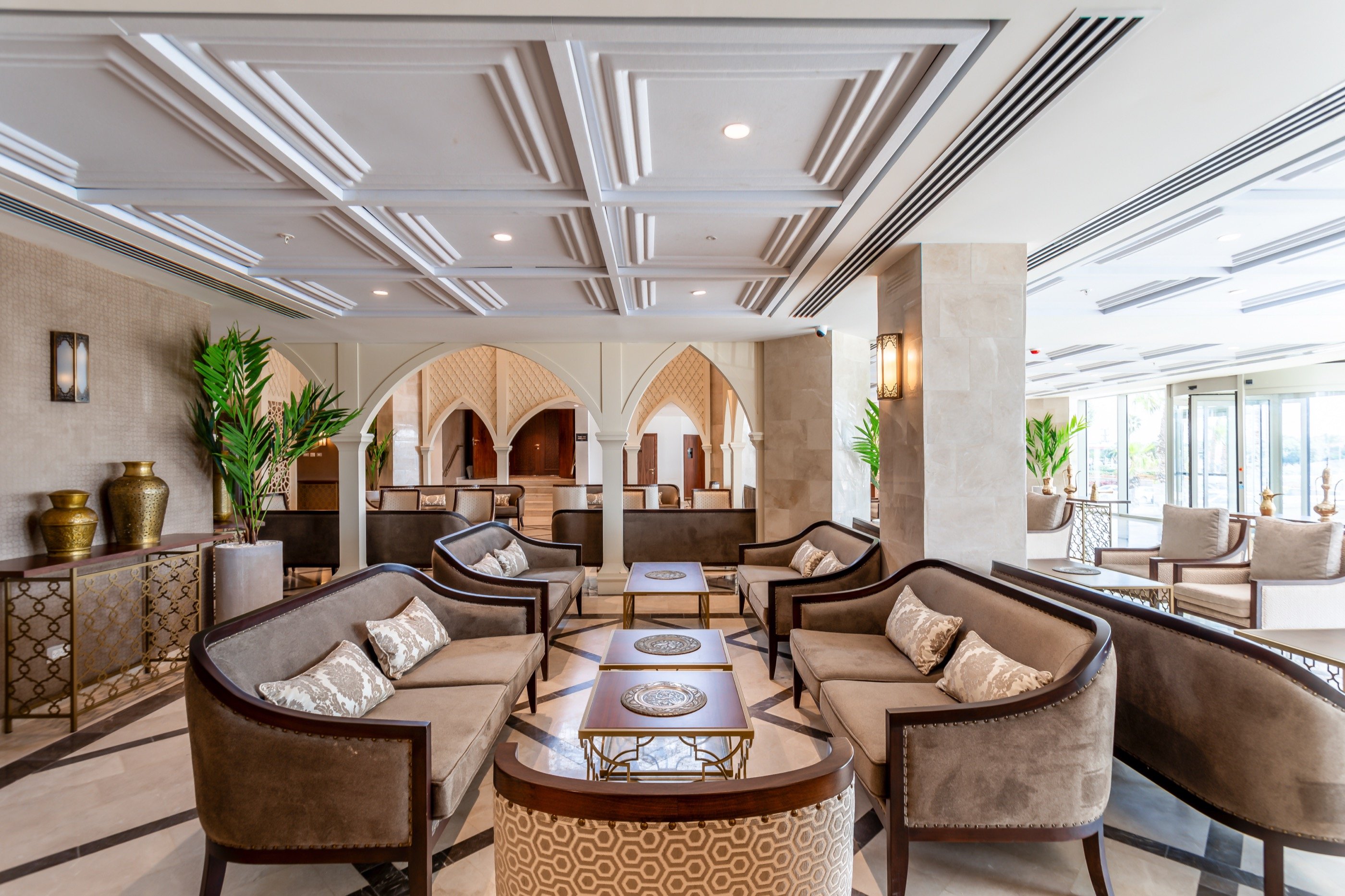 Velvet chairs under a coffered ceiling.