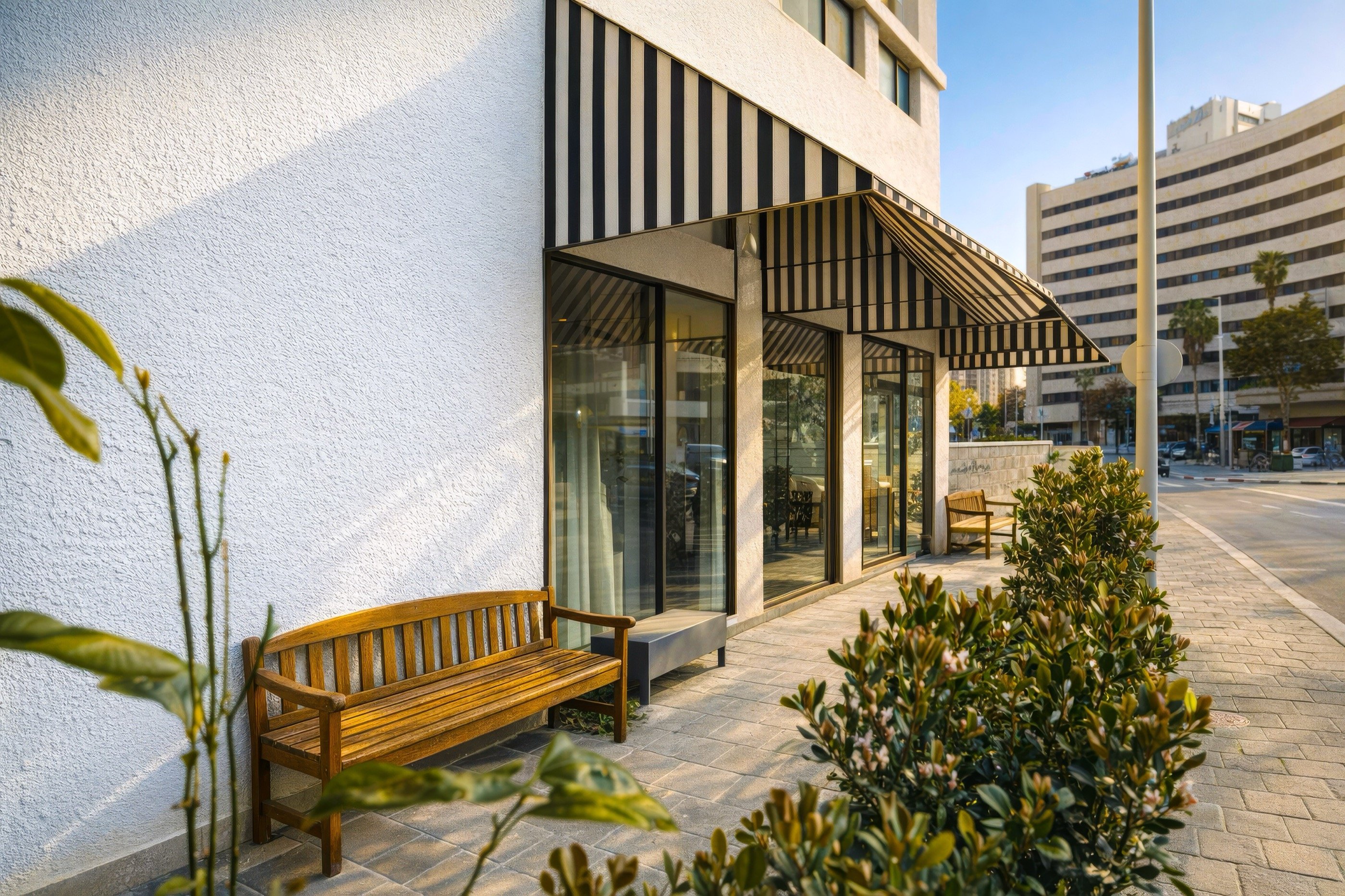 Striped awning, a bench, a Tel Aviv morning.