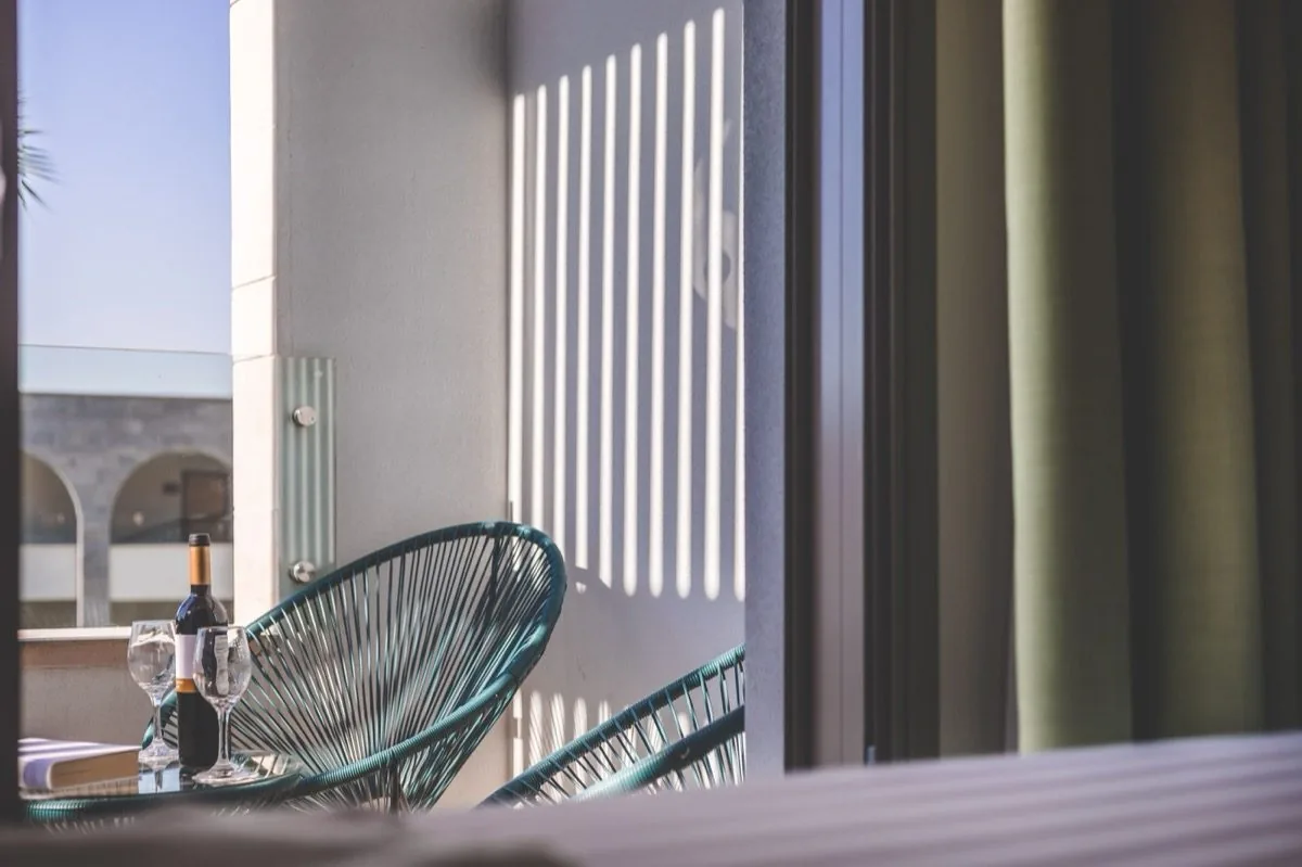A balcony holds the shadow of its railing.