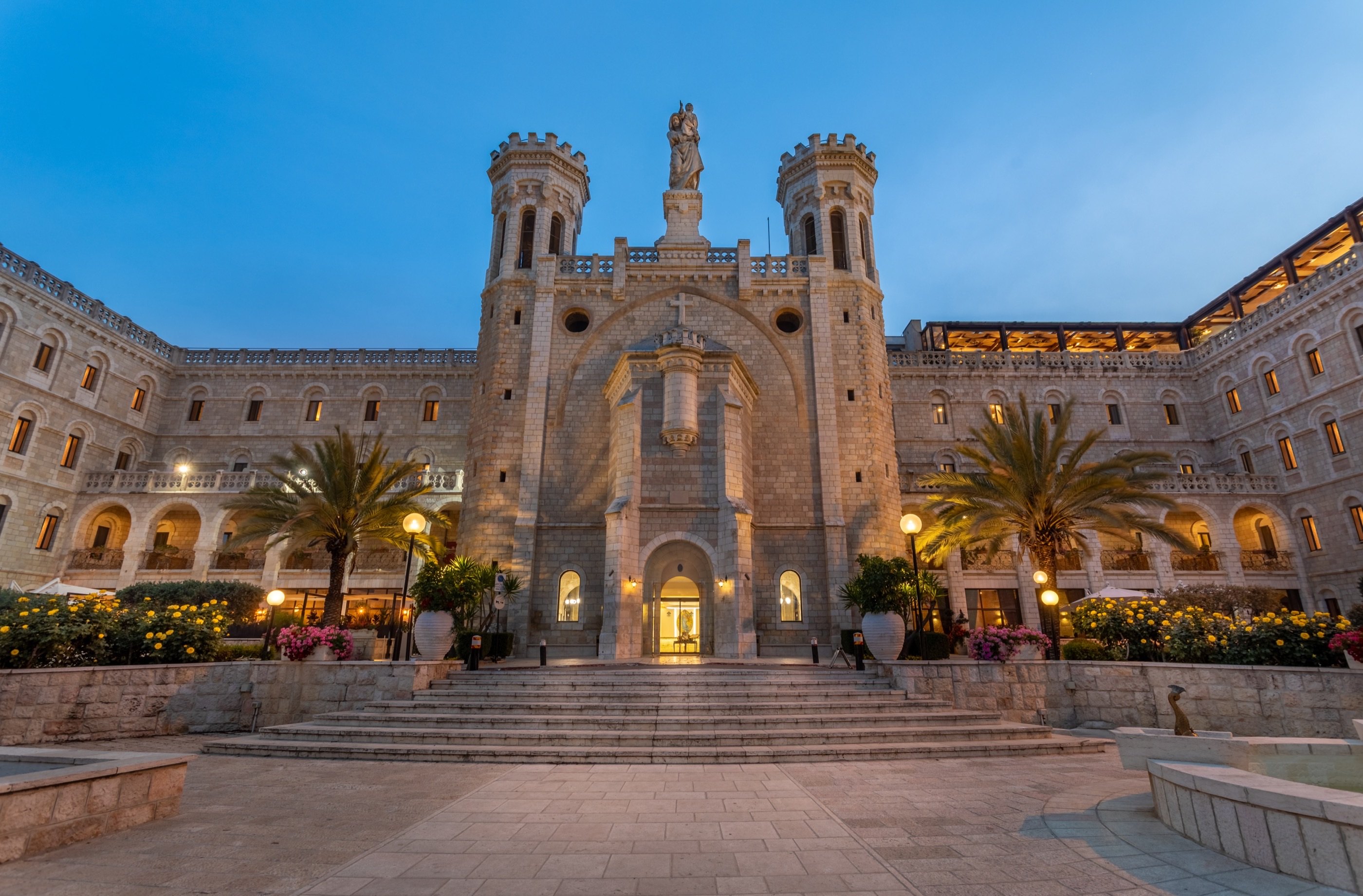 Blue hour at the facade — the city waits below.